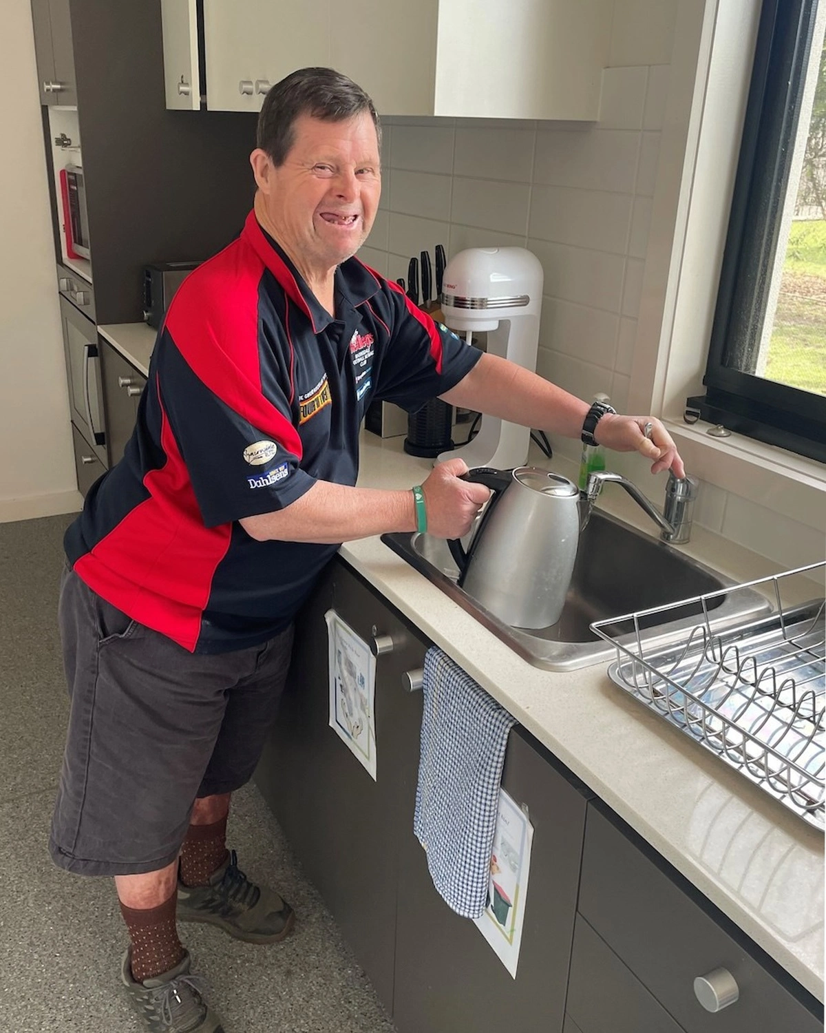 a man fills a kettle at NDIS registered disability service Distinctive Options Supported accommodation