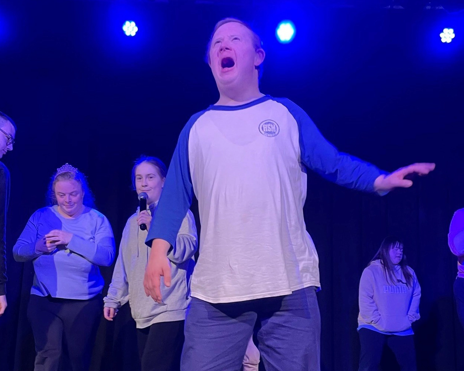 A man sings on stage at NDIS registered disability service Distinctive Options